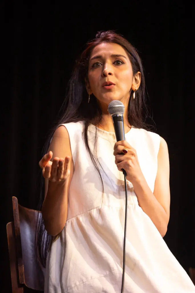 A young woman in white dress on the stage talking with the audience at the Symposium of a movie - Tokyo Portrait Photographer