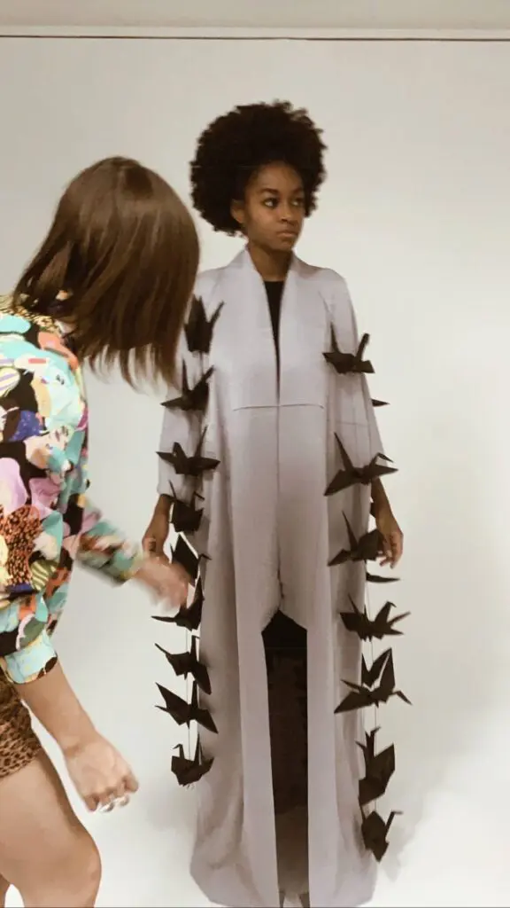 A female model is getting ready in a long white dress with many black paper bats - Tokyo Portrait Photographer