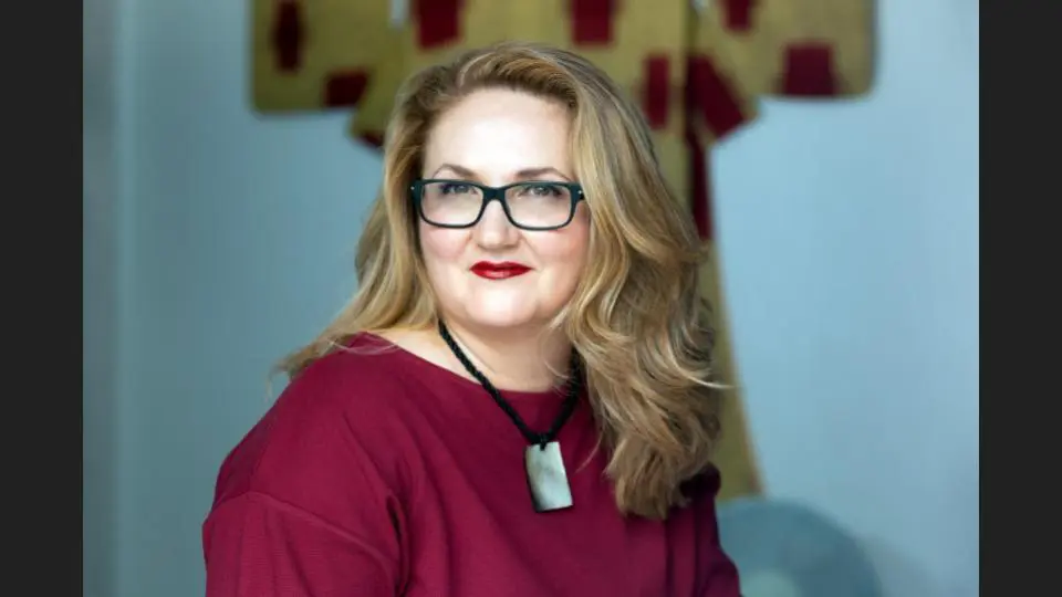 A woman with glasses & golden hair in a red top smiling at the camera indoors - Tokyo Portrait Photographer, Headshot photos