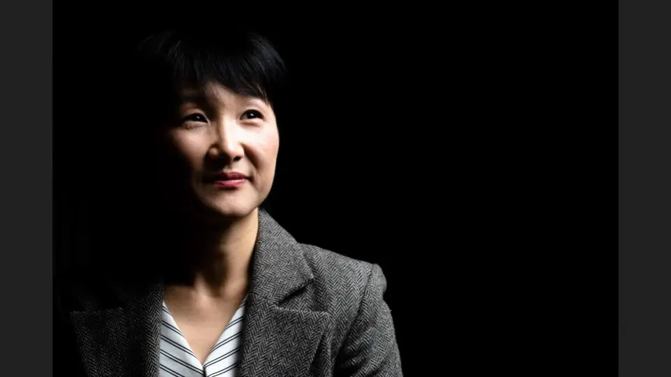 Headshot of a woman with a dark background, wearing a grey overcoat - Tokyo Portrait Photographer, Headshot photos