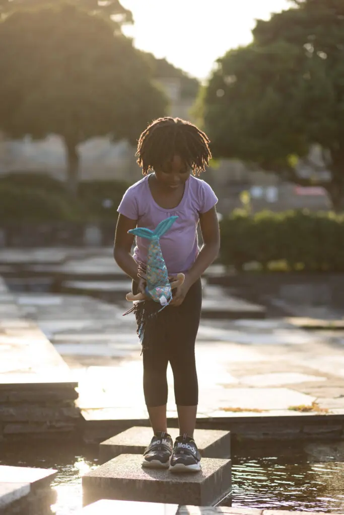 A young little girl in a swimming outfit standing over a pond with her toy - Tokyo Portrait Photographer, Headshot photos