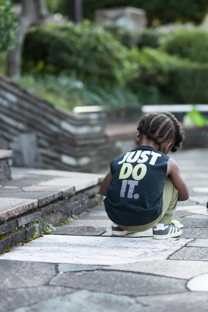 Back shot of kid in a park-like area doing something with focus - family photography, lifestyle photography