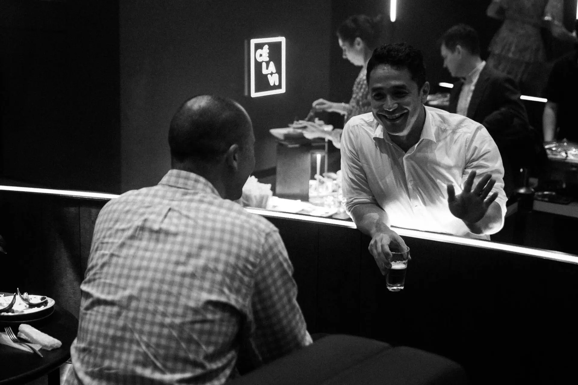 Black and white portrait of a man with a drink smiling at a bartender in a cafe - Event photographer, Tokyo Event Photography, Tokyo Portrait Photographer, Photographer in Tokyo