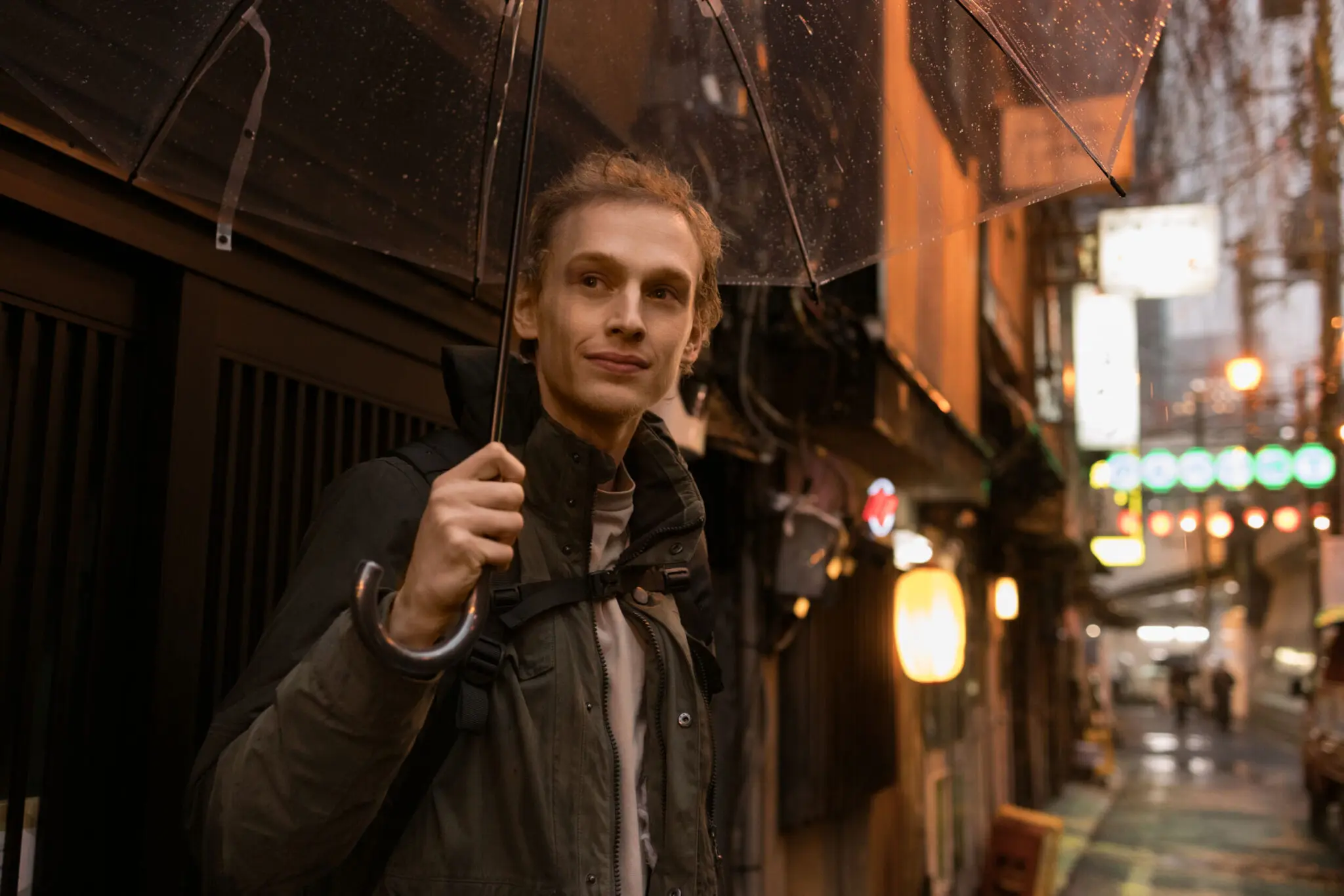 Young man with umbrella in Tokyo street, showcasing vibrant city life, Tokyo Portrait Photographer, Japan Photography