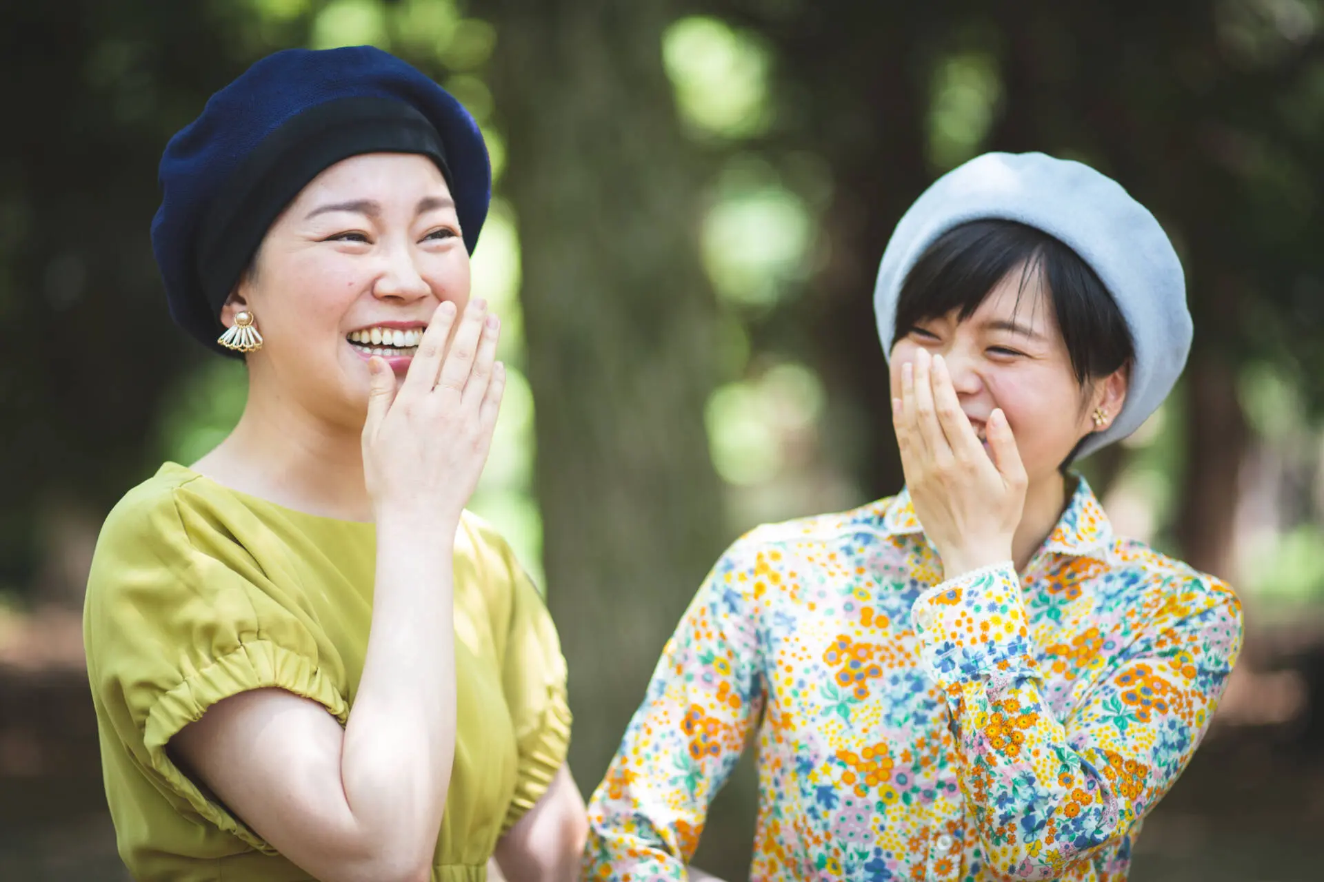 A candid shot of two women in a fancy dress and a hat laughing together - family photography, lifestyle photography, Tokyo Portrait Photographer, Photographer in Tokyo