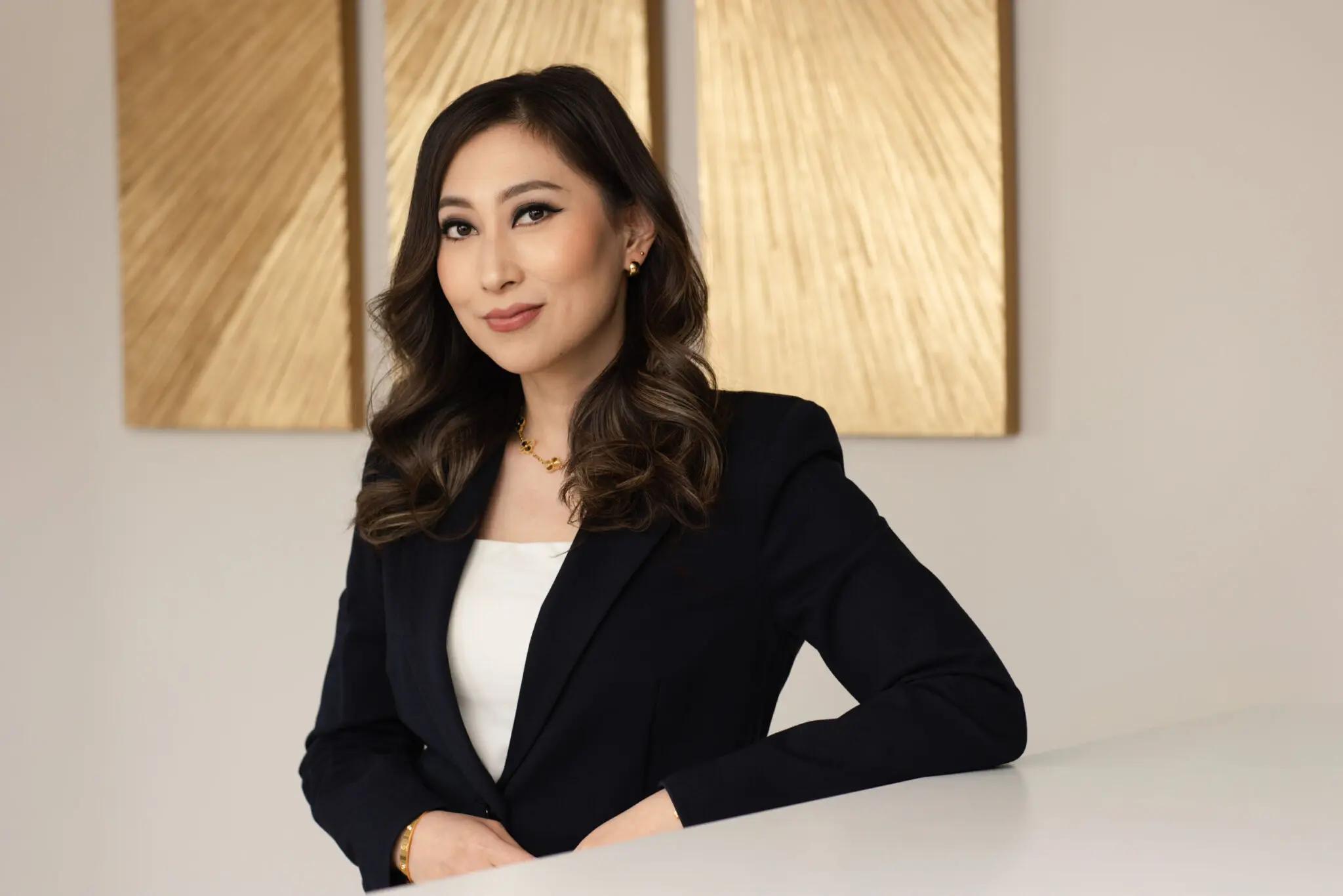Professional headshot of an Asian woman wearing a black blazer