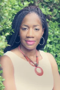 Outdoor portrait of Brandi Salley with braided hair and a bold necklace, showing confidence and grace. Photo by Tia Haygood.