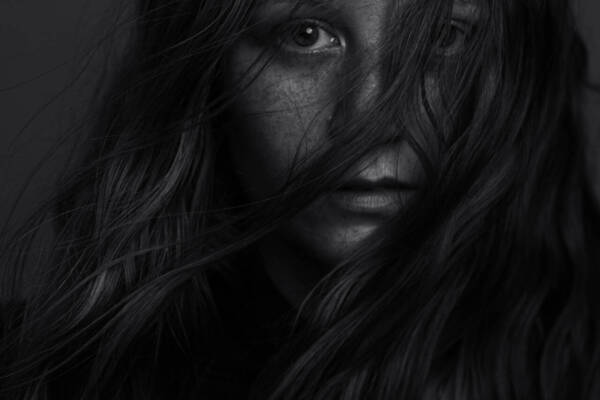 A woman with long hair covering her face