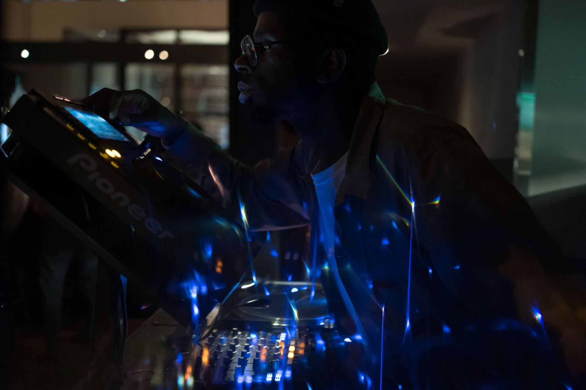 A close-up dark portrait of a DJ operating the sound system at a party - Event photographer, Tokyo Event Photography, Tokyo Portrait Photographer, Photographer in Tokyo