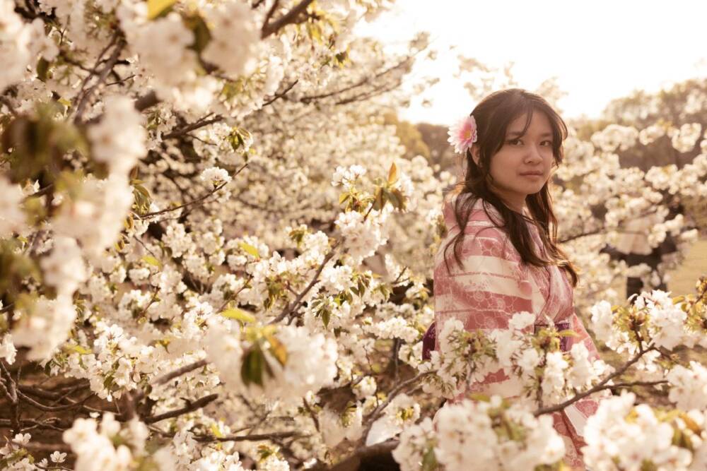 Portrait of a young adult girl standing beside cherry tree bloom in the daylight - Family photography, Lifestyle photography