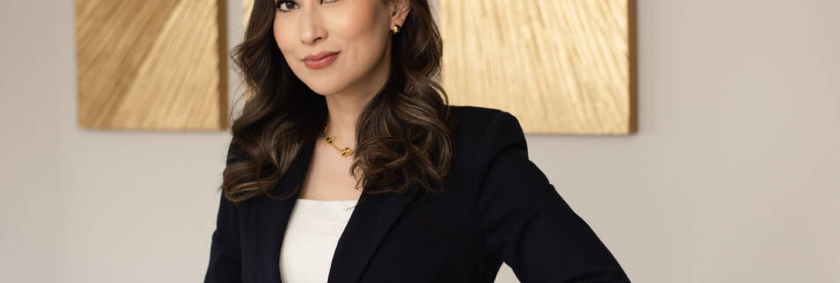 Professional headshot of an Asian woman wearing a black blazer