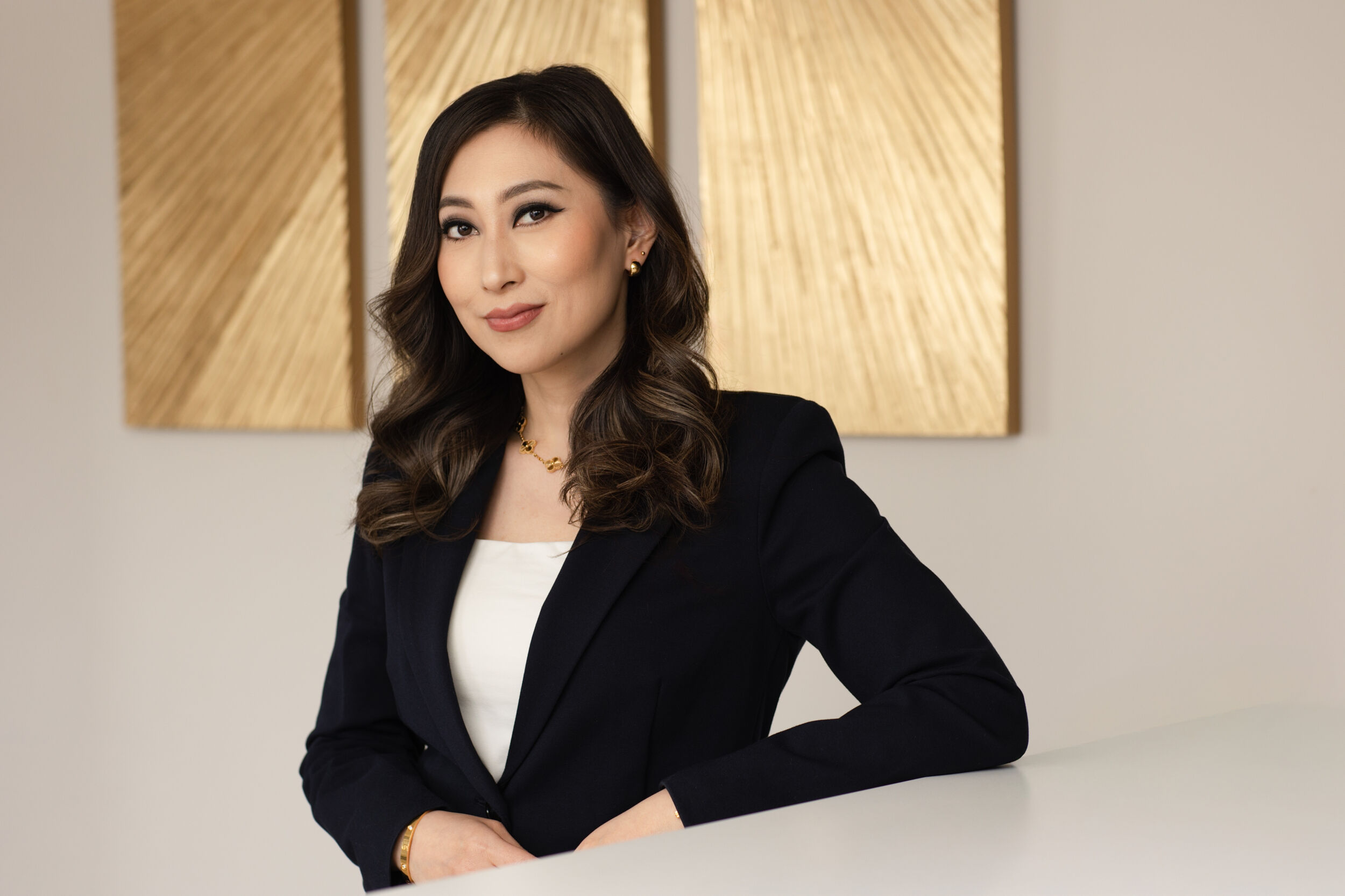 Professional headshot of an Asian woman wearing a black blazer