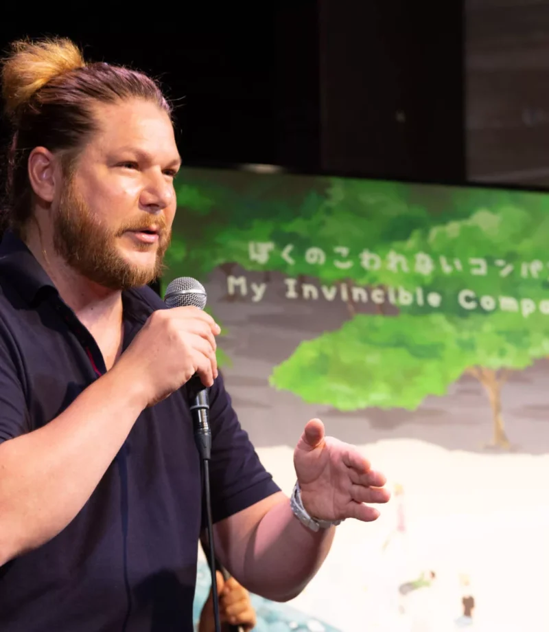 Closeup shot of a man in a black shirt talking in mic with the people at a symposium of a movie - Tokyo Portrait Photographer