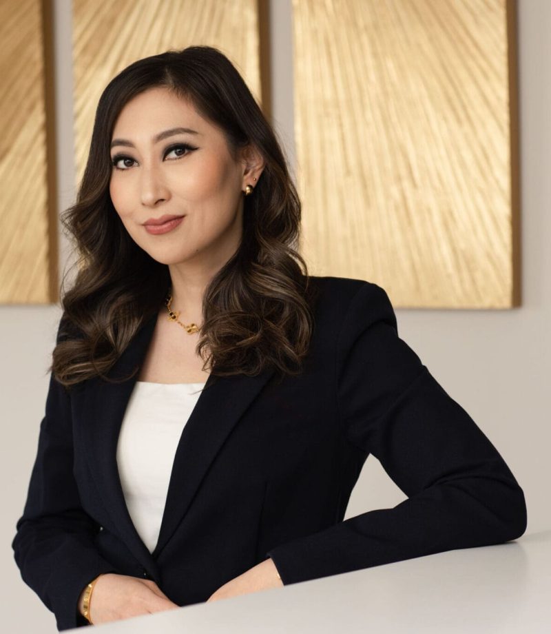 Professional headshot of an Asian woman wearing a black blazer