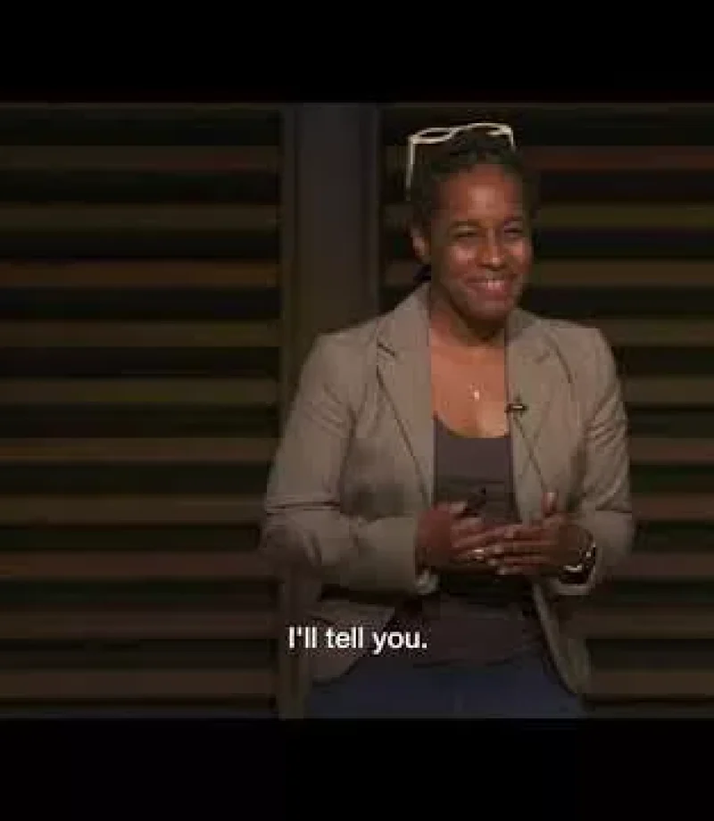 A smiling humble woman in a formal outfit talking with attendees from the stage - Photographer in Tokyo, Japan Photography